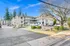 Bright and inviting apartment community with ample parking, lush greenery, and modern architecture under a clear blue sky.