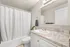 Elegant bathroom featuring a granite countertop, pristine white sink, and a well-lit mirror, creating a serene atmosphere.