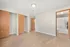 Spacious bedroom with hardwood floors, ample closet space, and modern lighting, adjacent to a bright bathroom.