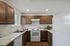 Modern kitchen with sleek marble countertops, rich wooden cabinets, and high-end appliances, creating a stylish cooking space.