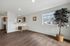 Bright, open-concept living area featuring sleek hardwood floors, a well-appointed kitchen with modern cabinetry, and a large window with scenic views.