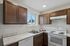 Bright and inviting kitchen with elegant dark wood cabinets, sleek marble countertops, and modern appliances, perfect for culinary creations.