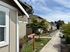Charming residential street with modern townhouses, lush greenery, and a welcoming office sign, perfect for a tranquil living environment.