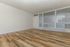 Inviting living room with sleek wood flooring, large windows, and natural light, perfect for a cozy retreat.