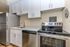 Modern kitchen with sleek stainless steel appliances, elegant white cabinetry, and a stylish countertop in a chic apartment.