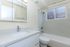 Bright and modern bathroom featuring a sleek vanity, pristine shower, and large mirror.