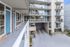 Modern apartment building facade showcasing elegant glass balconies and a sleek entryway.