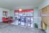 Inviting apartment entryway with stylish red-accented chairs, modern lighting, and convenient mailboxes, offering a warm welcome.