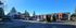 Charming apartment complex surrounded by lush greenery, featuring modern architecture and ample parking under a clear blue sky.