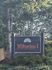 Inviting Wilburton I Apartments sign nestled among lush greenery, offering a tranquil and welcoming atmosphere.