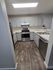 Modern kitchen with sleek stainless steel appliances, elegant white cabinetry, and warm wood flooring for a stylish culinary experience.