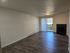 Bright and inviting living room with sleek hardwood floors, cozy fireplace, and large sliding glass doors leading to a scenic balcony.