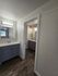 Modern apartment bathroom with elegant dual sinks, stylish cabinetry, and sleek lighting on wood flooring.