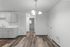 Modern apartment showcasing an elegant kitchen with sleek cabinetry, stylish light fixture, and exquisite wood flooring.