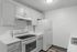 Chic monochrome kitchen with modern appliances, sleek cabinetry, and elegant marble countertops.
