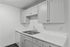 Sleek modern kitchen with elegant cabinetry, dual sink, and spacious white marble countertops.
