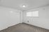 Bright and spacious bedroom with soft carpet, large window for natural light, and a sleek sliding closet.