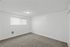Bright and cozy room with fresh white walls, soft carpeted floor, and a large window inviting natural light.