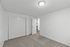 Bright, clean bedroom with modern lighting, plush carpet, and convenient closet space, offering a cozy and inviting atmosphere.