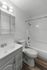 Contemporary bathroom with sleek vanity, stylish fixtures, and elegant wood-like flooring for a modern touch.