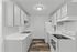 Bright, modern kitchen with sleek white cabinets, elegant countertops, and a pristine wooden floor.