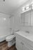 Elegant bathroom featuring sleek white fixtures, a modern vanity, and stylish lighting, perfect for a serene and refreshing ambiance.