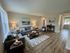Inviting living room with modern furniture, cozy gray sofas, stylish decor, and natural light streaming through large windows.