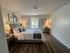 Inviting bedroom with elegant decor, featuring a plush bed, stylish lamps, and a window with a garden view, enhancing relaxation and comfort.