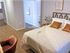 Elegant Centennial Ridge bedroom with modern decor, featuring a plush bed, stylish chair, and artistic wall art.