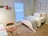 Centennial Ridge style bedroom with a plush bed, soft pink and grey accents, and modern decor.