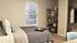 Inviting Centennial Village bedroom with stylish decor, featuring a comfortable bed, modern shelving, and natural light.