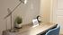Stylish desk setup with modern lamp, clock, and green plant in Centennial Village apartment emphasizing largest bedrooms in Raleigh.