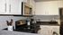 Contemporary Centennial Village kitchen with sleek black appliances, white cabinets, and stylish decor.