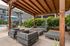 Chic outdoor lounge area in Chase Courtyard apartment complex with cozy seating around a stylish fire pit, featuring a modern pergola and a nearby poolside setting.