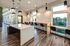 Modern kitchen island with pendant lighting and panoramic windows at The Flats at Chase in Eugene, OR