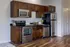 Modern kitchen featuring sleek stainless steel appliances, elegant dark wood cabinetry, and a cozy breakfast nook with stylish bar stools.
