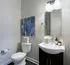 Elegant modern bathroom featuring sleek fixtures, a stylish sink, and chic wall art in a cozy, well-lit space.