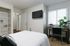 Furnished bedroom with wall-mounted TV and natural light at Stadium Park in Eugene OR