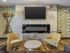 Republic on Main clubhouse living room with stylish yellow armchairs, sleek fireplace, wall-mounted TV, and artistic wallpaper in Moscow, ID