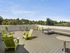 Republic on Main rooftop terrace with vibrant green chairs, cozy seating, and panoramic views of lush greenery under a bright blue sky in Moscow, ID