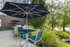 Outdoor patio with shaded umbrella seating area at The Landings riverside apartment community Knoxville TN