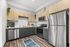 Modern kitchen with sleek stainless steel appliances, stylish two-tone cabinetry, and elegant hardwood flooring.