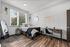 Bright and modern bedroom featuring a cozy bed, stylish desk, and large window with a garden view.