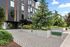 Modern apartment building entrance at The Flats @ Chase, surrounded by lush greenery and sleek architectural design, ideal for contemporary student living.