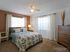 La Aloma Apartments, interior, bedroom, carpet, bed, dresser, two windows, ceiling fan