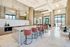Bright, airy dining and entertaining area with large windows, high ceilings, marble floors, a catering kitchen with a 10-person marble dining table, and multiple seating areas and tables with chairs.