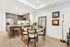 Open-concept apartment kitchen and dining space with a 4-person round dining table, ash-gray kitchen cabinets, light wood-style floors, and a recessed ceiling.