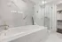 Master bathroom with floor-to-ceiling marble tile, a glass walk-in shower, a full-size soaking tub, and a walk-in closet.
