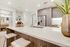 Close-up of a kitchen peninsula with an ecru-colored quartz countertop and an undermount sink with a detachable faucet.