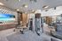 Weight machines, SkillMill treadmills, Eschelon-on-demand spin bikes, and a flat-screen TV.